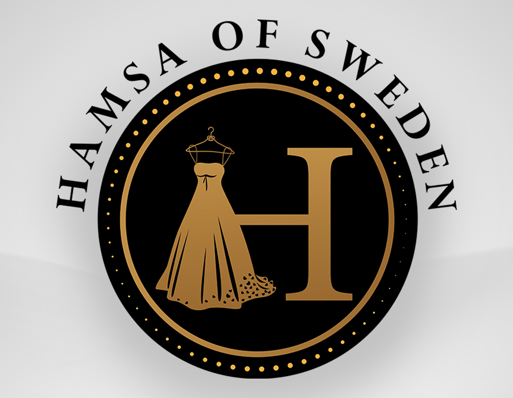 En logga föreställande en svart cirkel med Ett stort guldigt H i mitten av. H:ets vänstra ben är utbytt mot en bröllopsklänning hängandes på en galje. Ovanför cirkeln står det Hamsa fo sweden i en båge med svart tect.